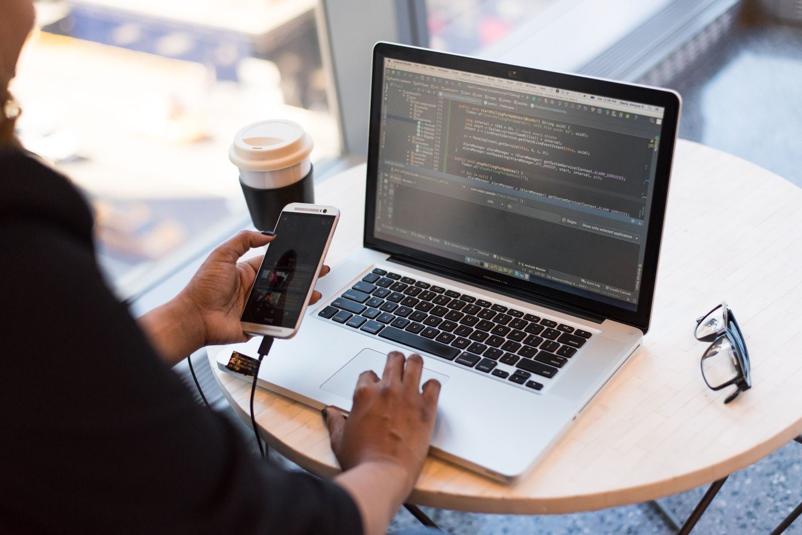 Working from a café table with a laptop and phone