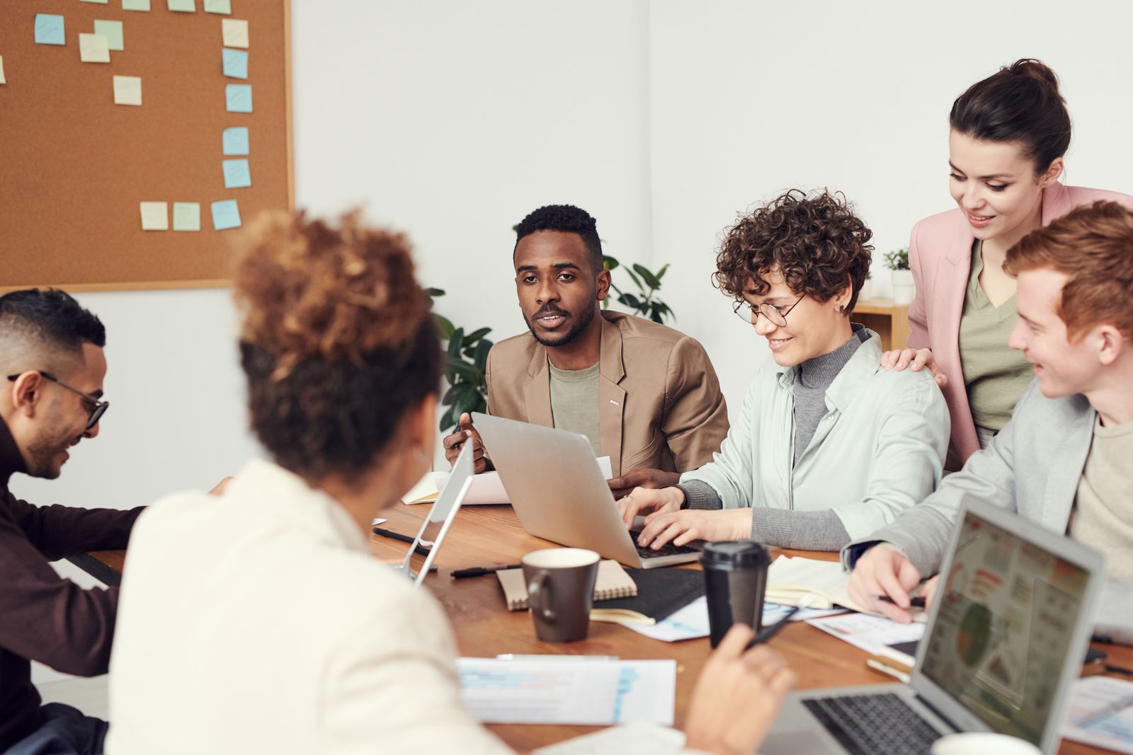 An agency team collaborating around a table of laptops